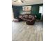 Living room featuring a reclining sofa with wood-look tile floors and a modern painting at 5804 Balzar Ave, Las Vegas, NV 89108