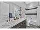 Modern bathroom with double sinks, large mirror, and tiled shower and tub combo at 6184 Willow Rock St, Las Vegas, NV 89135
