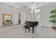 Spacious living room with high ceilings, piano, and wood look tile flooring at 6184 Willow Rock St, Las Vegas, NV 89135