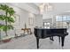 Bright living room with high ceilings, piano, and wood look tile flooring at 6184 Willow Rock St, Las Vegas, NV 89135
