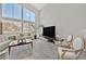 Living room with a view of a big screen tv and expansive windows at 6184 Willow Rock St, Las Vegas, NV 89135