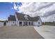 Striking exterior view of a two-story home with large windows and a spacious gravel driveway at 6235 Westwind Rd, Las Vegas, NV 89118