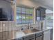 This kitchen features stainless steel appliances and a window overlooking the backyard pool at 6235 Westwind Rd, Las Vegas, NV 89118
