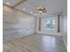 Bright and airy living room with wood-paneled accent wall, a window, and modern flooring at 6235 Westwind Rd, Las Vegas, NV 89118