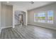 Well-lit living room features modern floors, staircase, large window, and neutral decor at 6235 Westwind Rd, Las Vegas, NV 89118