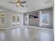 Bright living room with gray flooring and accent wall, ceiling fan, and patio access at 6235 Westwind Rd, Las Vegas, NV 89118
