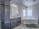 Elegant main bathroom featuring a soaking tub, vanity, and tile flooring at 6235 Westwind Rd, Las Vegas, NV 89118