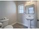 Cozy powder room with pedestal sink, framed mirror and white fixtures at 6235 Westwind Rd, Las Vegas, NV 89118