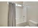 Bright white bathtub and shower combo with gray shower curtain at 7380 Abundant Harvest Ave, Las Vegas, NV 89131