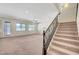 Bright entryway with stairs and ornate iron railing leading to the second floor of the home at 7380 Abundant Harvest Ave, Las Vegas, NV 89131