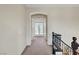 Upstairs hallway with carpet, arched doorway, and view to french doors at end of hall at 7380 Abundant Harvest Ave, Las Vegas, NV 89131