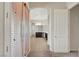 Hallway featuring neutral walls, tile floor, arched doorway and a view to the bathroom and a bedroom at 7380 Abundant Harvest Ave, Las Vegas, NV 89131