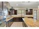 Modern kitchen with dark wood cabinets, stainless steel appliances, and granite countertops at 7380 Abundant Harvest Ave, Las Vegas, NV 89131