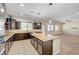 Well-lit kitchen featuring a center island, granite countertops, and open access to the living area at 7380 Abundant Harvest Ave, Las Vegas, NV 89131