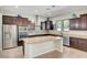 Modern kitchen featuring granite countertops, stainless steel appliances, and stylish dark wood cabinetry at 7380 Abundant Harvest Ave, Las Vegas, NV 89131