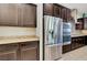 Close up of a modern kitchen with stainless steel refrigerator, oven, and granite countertops at 7380 Abundant Harvest Ave, Las Vegas, NV 89131