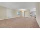 Expansive living room with neutral carpet, arched doorway, and ample natural light creating an inviting space at 7380 Abundant Harvest Ave, Las Vegas, NV 89131