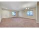 Bright living room with a double-door entryway, neutral walls, and ample sunlight from two windows at 7380 Abundant Harvest Ave, Las Vegas, NV 89131