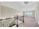 Bright and airy loft area featuring carpeted floors and wrought iron railing detail at 7380 Abundant Harvest Ave, Las Vegas, NV 89131