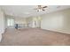 Large, carpeted loft area with stylish railing and access to a balcony through glass doors at 7380 Abundant Harvest Ave, Las Vegas, NV 89131