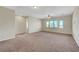 Open loft area with neutral carpet and large windows, providing ample natural light at 7380 Abundant Harvest Ave, Las Vegas, NV 89131
