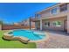 Backyard pool with lush landscaping and a covered patio, perfect for outdoor relaxation at 7380 Abundant Harvest Ave, Las Vegas, NV 89131