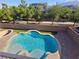 Backyard swimming pool with tanning deck and surrounded by lush landscaping at 7380 Abundant Harvest Ave, Las Vegas, NV 89131