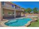 Back of house with a pristine pool, manicured lawn, and patio, perfect for outdoor living and entertaining at 7380 Abundant Harvest Ave, Las Vegas, NV 89131