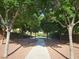 Scenic walking path surrounded by mature trees and lush landscaping at 7380 Abundant Harvest Ave, Las Vegas, NV 89131