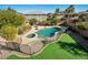 Private backyard with a sparkling pool, spa, lush landscaping, and an artificial grass area at 7520 Fontera Ct, Las Vegas, NV 89139