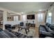Open-concept living room featuring neutral walls, shutters, a large TV, and stylish furniture at 7520 Fontera Ct, Las Vegas, NV 89139
