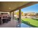 Covered patio with outdoor seating overlooking the pool and well-maintained backyard at 7520 Fontera Ct, Las Vegas, NV 89139