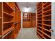 Organized walk-in closet with custom wood shelving, drawers, and cabinets for storage at 7520 Fontera Ct, Las Vegas, NV 89139