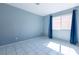 Bright bedroom with large window and tiled flooring, offering a clean and spacious living area at 7728 Barbican Ct, Las Vegas, NV 89147