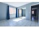 Spacious bedroom with tiled flooring and mirrored closet doors, providing ample storage space at 7728 Barbican Ct, Las Vegas, NV 89147