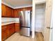 Updated kitchen features wood cabinets, stainless steel refrigerator, and pantry with shelving at 7863 Warwickshire Way, Las Vegas, NV 89139