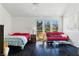 Bright bedroom with a double bed, seating area, and view of the landscaped backyard at 7988 Harbour Towne Ave, Las Vegas, NV 89113
