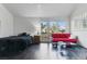 Bedroom with a black bed, a red futon, dark wood floors, and access to the backyard at 7988 Harbour Towne Ave, Las Vegas, NV 89113