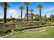 Elegant Spanish Trail entrance with stone sign, palm trees, and manicured landscaping at 7988 Harbour Towne Ave, Las Vegas, NV 89113