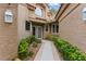 Inviting home entrance with a tiled walkway, green bushes, and stucco walls at 7988 Harbour Towne Ave, Las Vegas, NV 89113