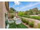 Charming patio area with lush landscaping and an outdoor dining set for relaxing at 7988 Harbour Towne Ave, Las Vegas, NV 89113