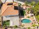Stunning aerial view showcases the home's tile roof, solar panels, lush backyard, pool, and covered patio at 8320 Deer Springs Way, Las Vegas, NV 89149