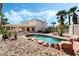 Spacious backyard featuring a pool, outdoor kitchen, covered patio, and lush greenery for outdoor living at 8320 Deer Springs Way, Las Vegas, NV 89149