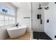 Bright bathroom featuring a modern soaking tub, black fixtures, and a stylish glass enclosed shower at 8320 Deer Springs Way, Las Vegas, NV 89149