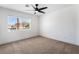 Bright bedroom features neutral carpet, a modern ceiling fan, and a window view at 8320 Deer Springs Way, Las Vegas, NV 89149