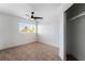 Bright, carpeted bedroom with a ceiling fan, window, and a closet with a hanging rod at 8320 Deer Springs Way, Las Vegas, NV 89149