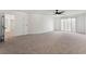 Spacious primary bedroom with neutral carpet, ceiling fan, and access to the covered balcony with sliding glass door at 8320 Deer Springs Way, Las Vegas, NV 89149