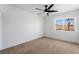 Bright bedroom features neutral carpet, a modern ceiling fan, and a window view at 8320 Deer Springs Way, Las Vegas, NV 89149