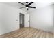 Spacious bedroom with light wood-look floors, a ceiling fan, and a door leading to another room at 8320 Deer Springs Way, Las Vegas, NV 89149