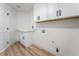 Functional laundry room with white cabinets, stylish hardware, and modern flooring at 8320 Deer Springs Way, Las Vegas, NV 89149
